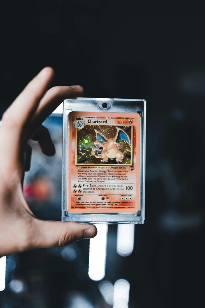 A detailed view of a Charizard Pokémon card held by a hand, iconic and collectible.